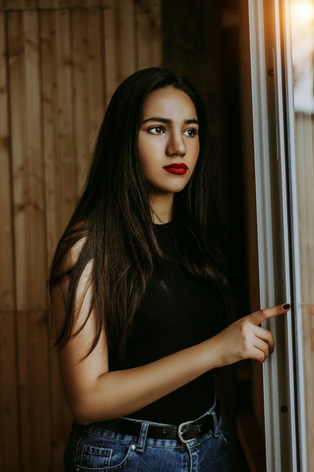 selective focus photography of woman leaning near window