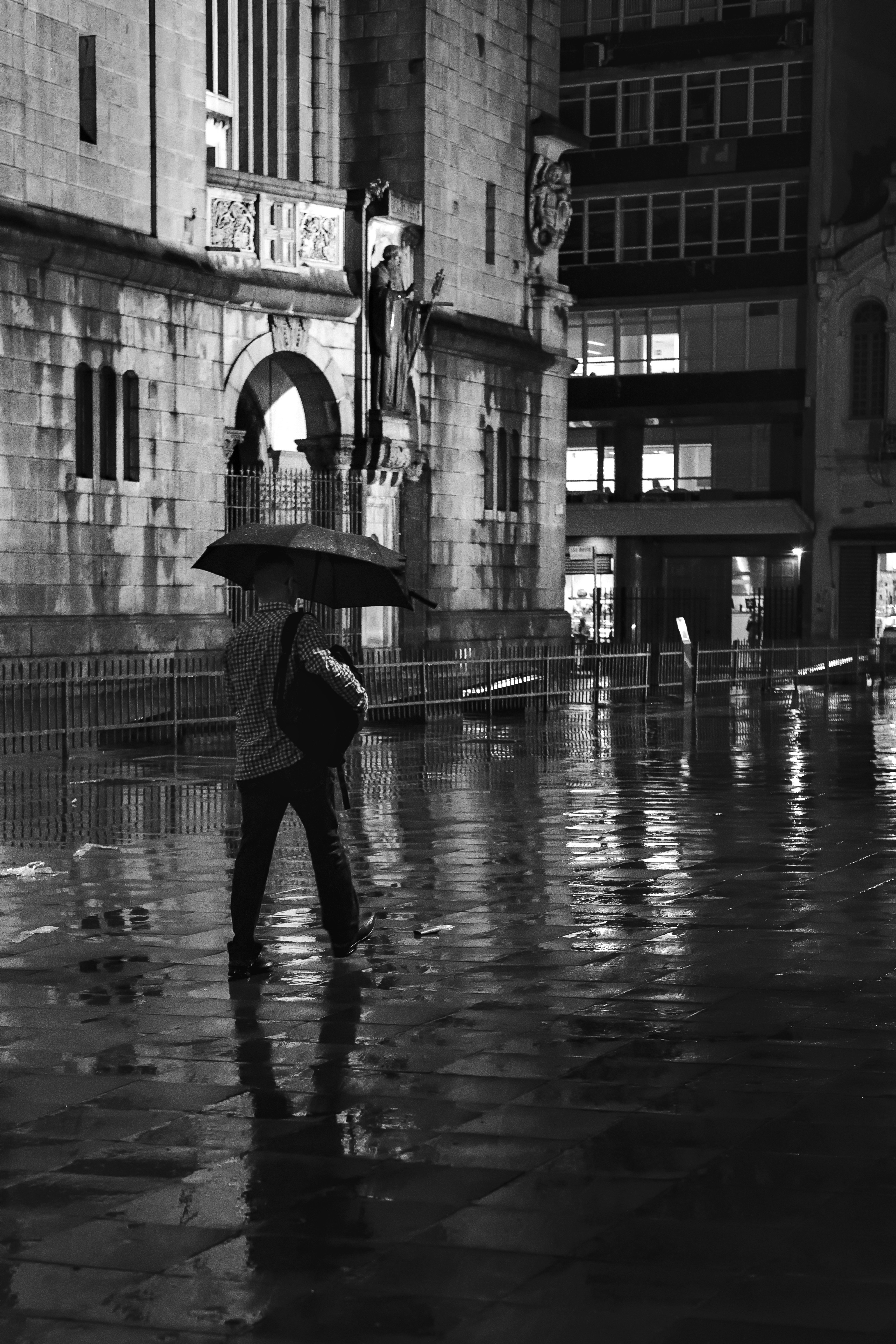 建物の近くを歩いたり傘をさしたりしている人