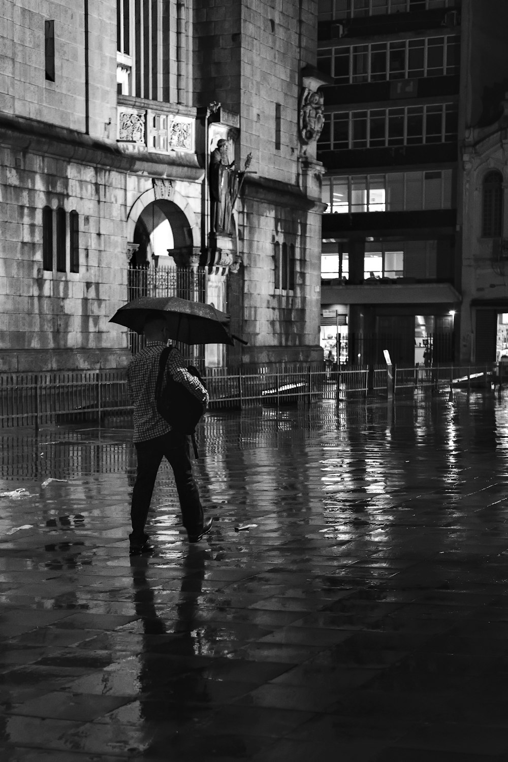 person walking and using umbrella near buildings