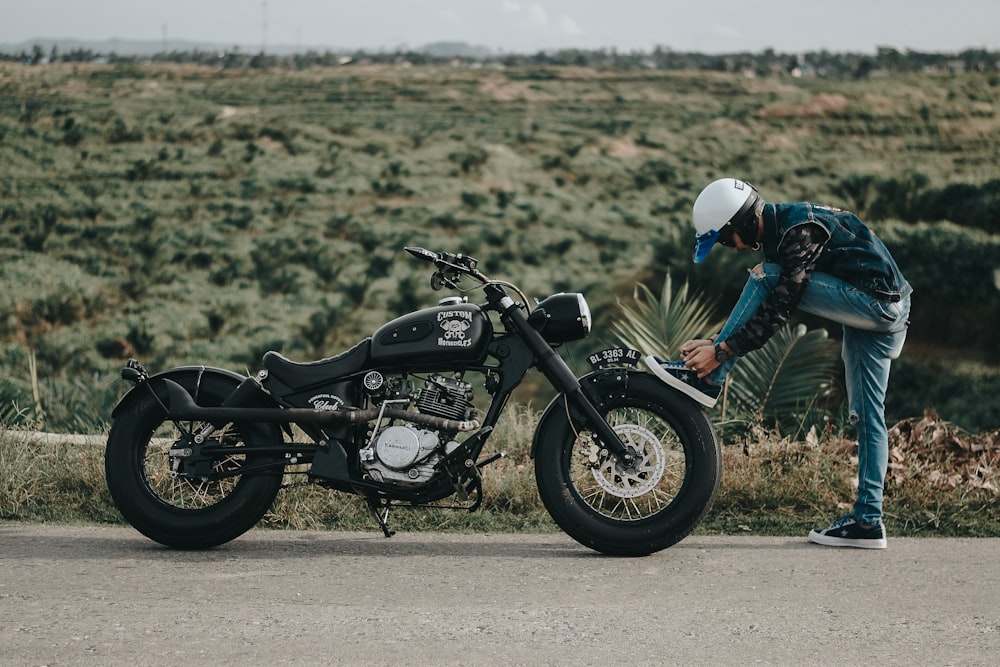 man standing beside motorcycle