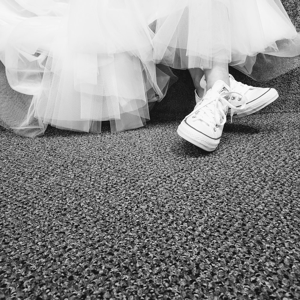 a black and white photo of a bride and groom's shoes