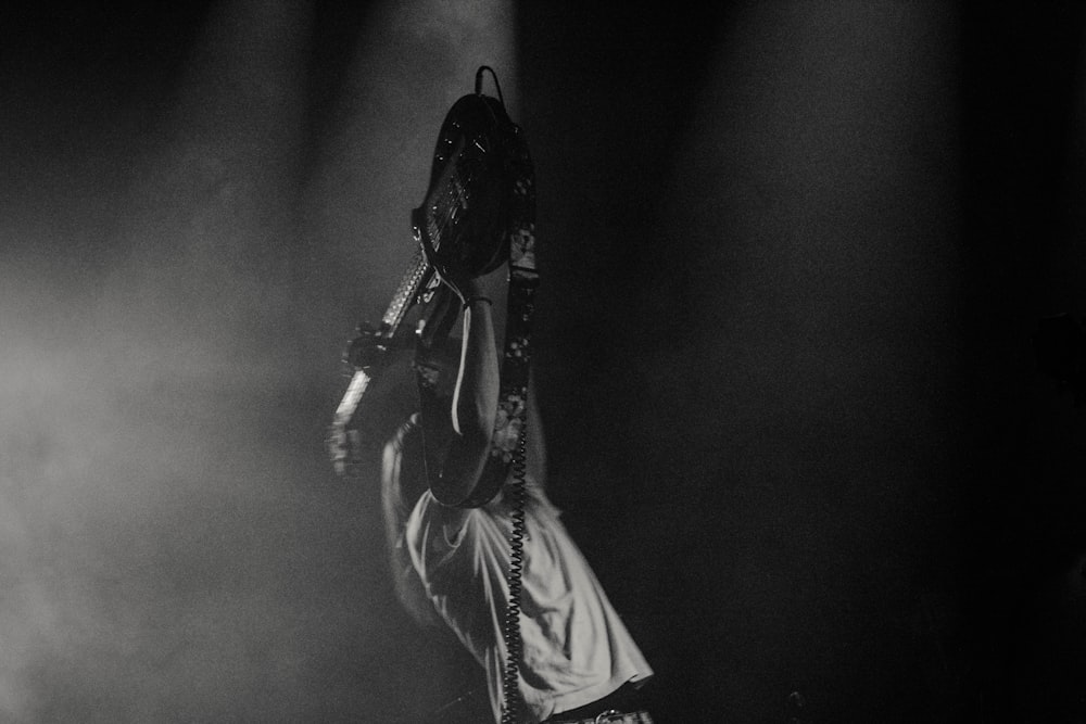 man lifting his electric guitar