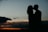 man and woman kissing during golden hour