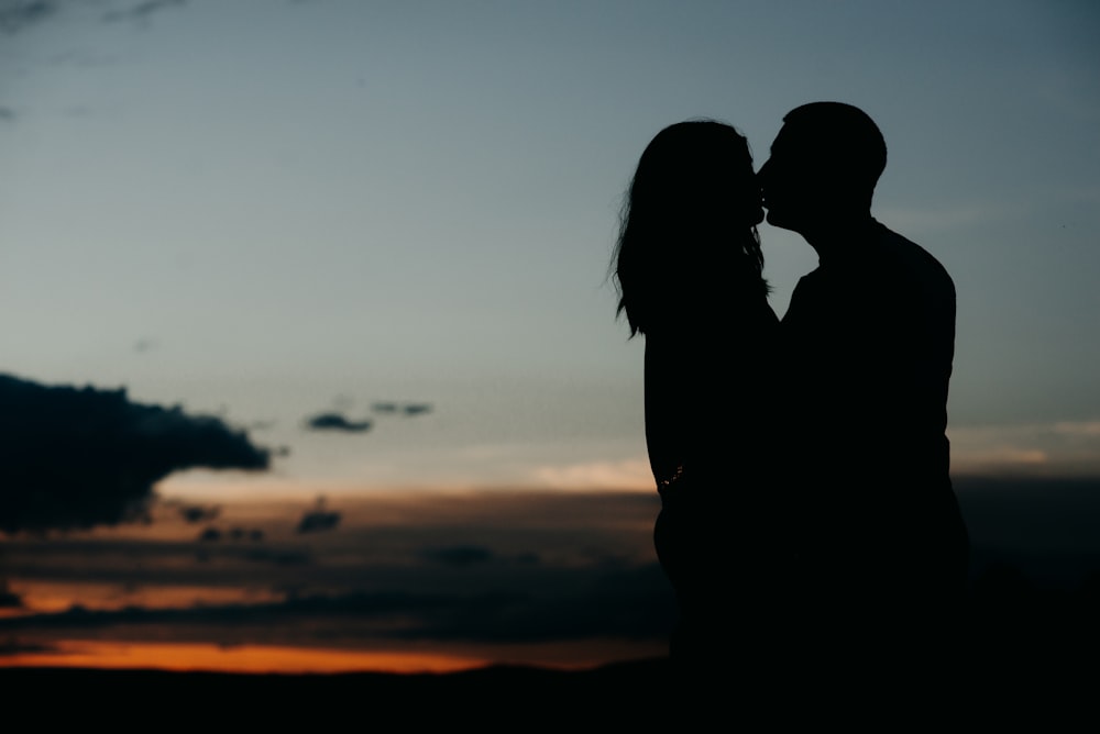 man and woman kissing during golden hour