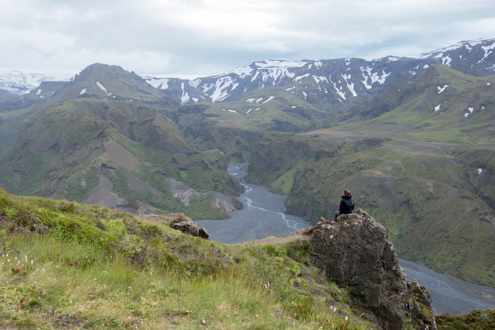 person sitting on top of rock