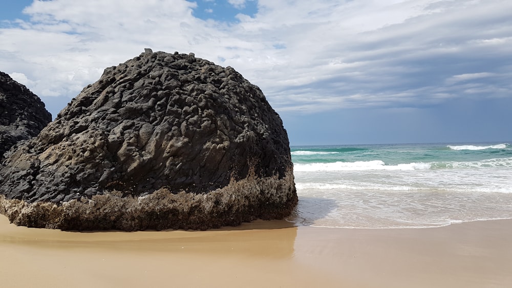 낮 동안 해변의 회색 바위