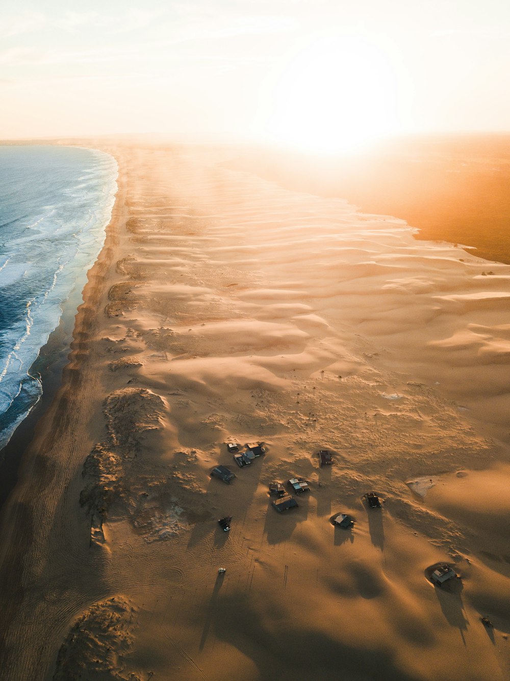 Véhicules sur le rivage au lever du soleil