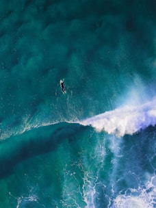 high-angle photography of man surfing giant wave