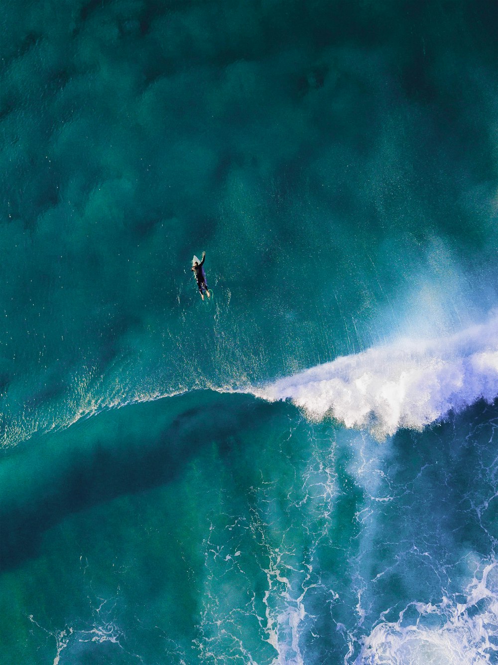 Fotografía de ángulo alto de hombre surfeando ola gigante