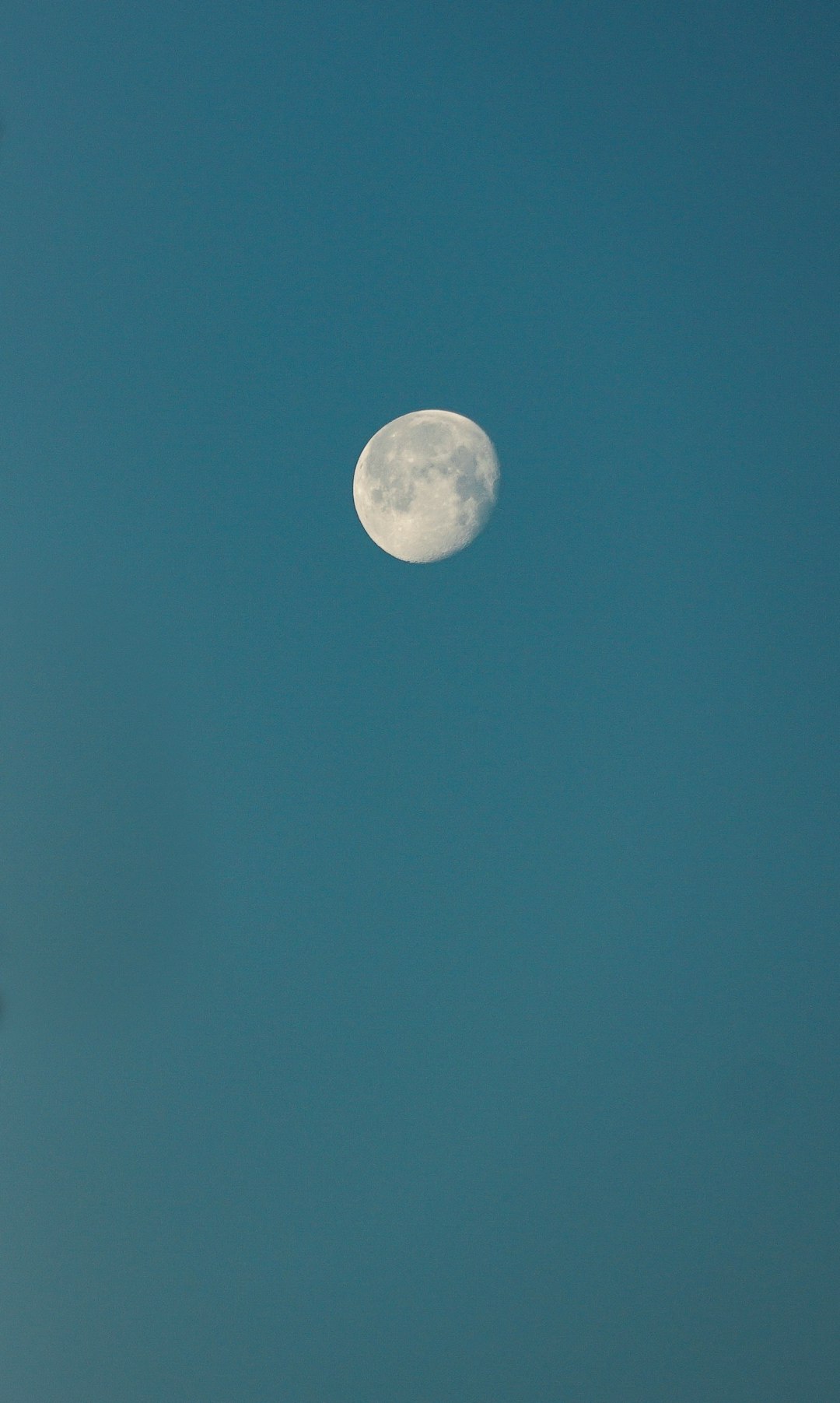 photo of full moon and blue sky