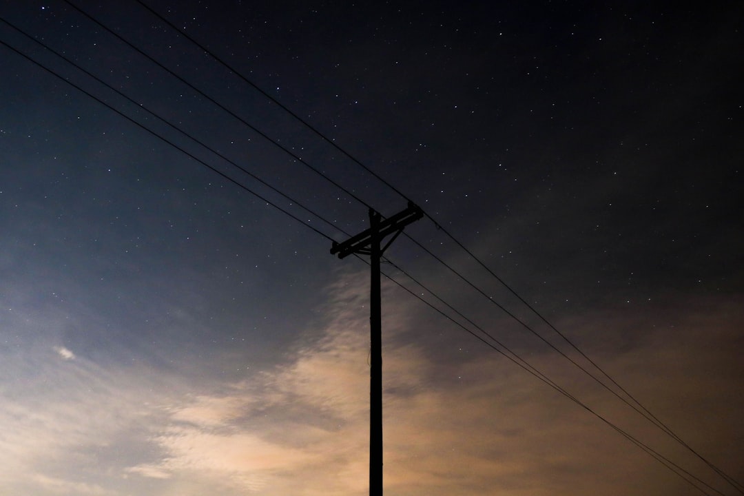 silhouette of electric post during nighttime
