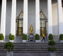 A serene temple entrance bathed in golden sunlight with devotees entering peacefully.
