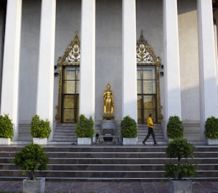A serene temple entrance bathed in golden sunlight with devotees entering peacefully.