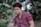 man wearing eyeglasses sitting near trees