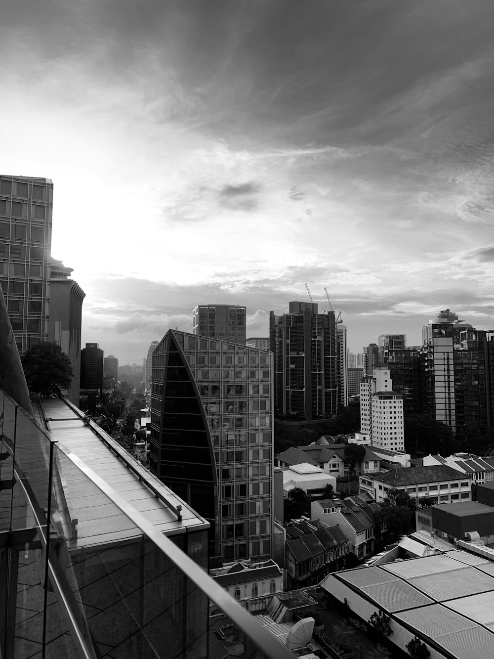 grayscale photo buildings under cloudy sky