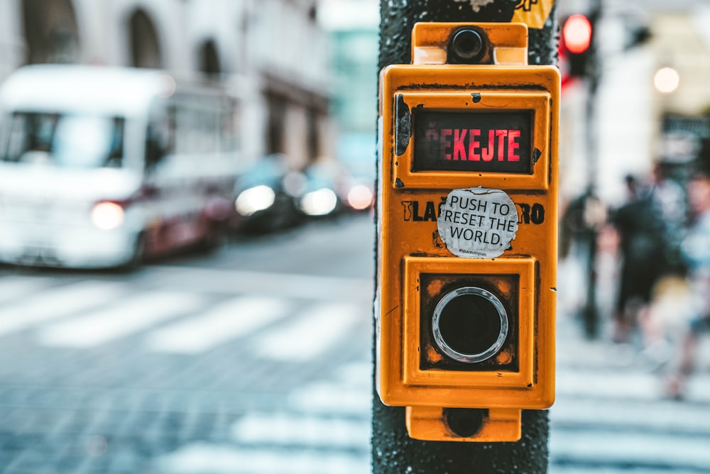 push to rest the world sticker on yellow pedestrian light switch