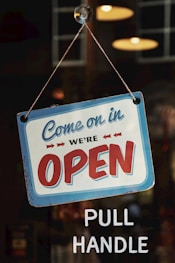 come on in we're open signage on glass panel