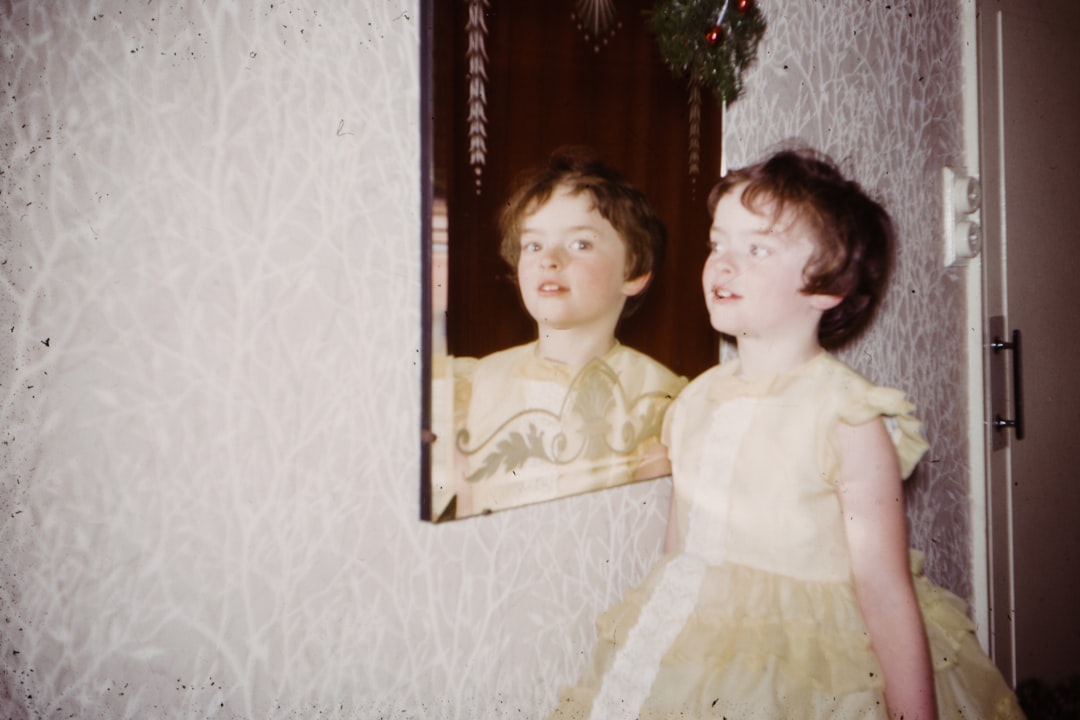 girl wearing beige dress standing in front of mirror