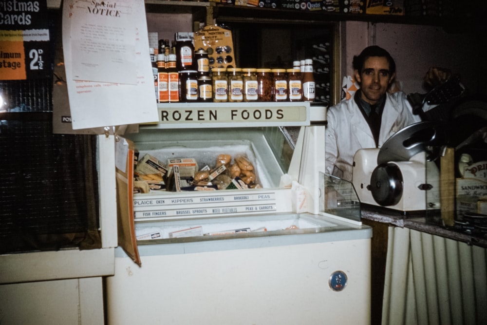 a man standing in front of an open refrigerator