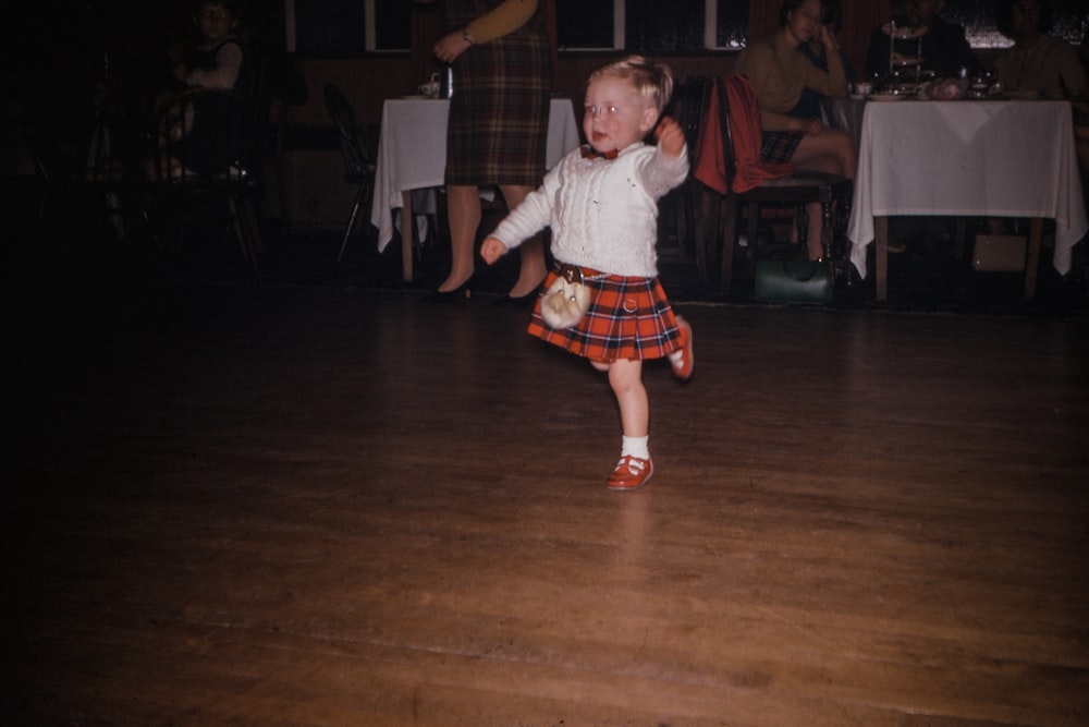 girl in white long-sleeved shirt dancing at the floor