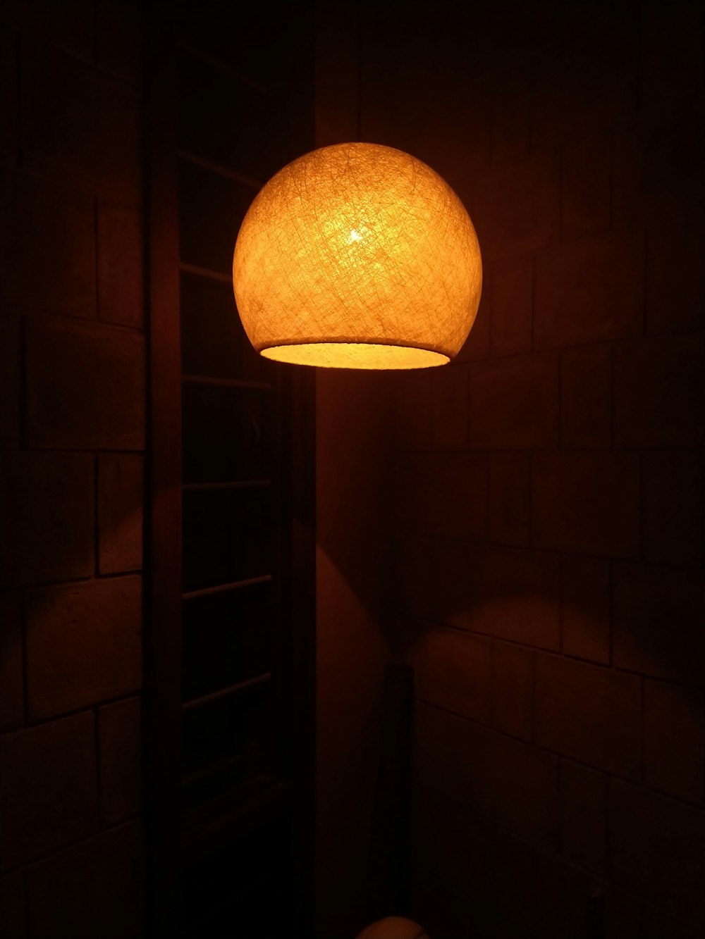 turned-on pendant lamp at the corner of the house