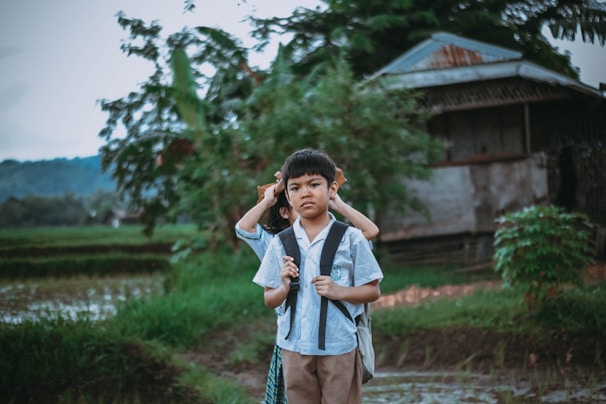 A smiling child receiving a school backpack from a volunteer in a rural village.