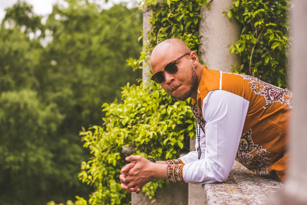 man with sunglasses leaning at the balcony