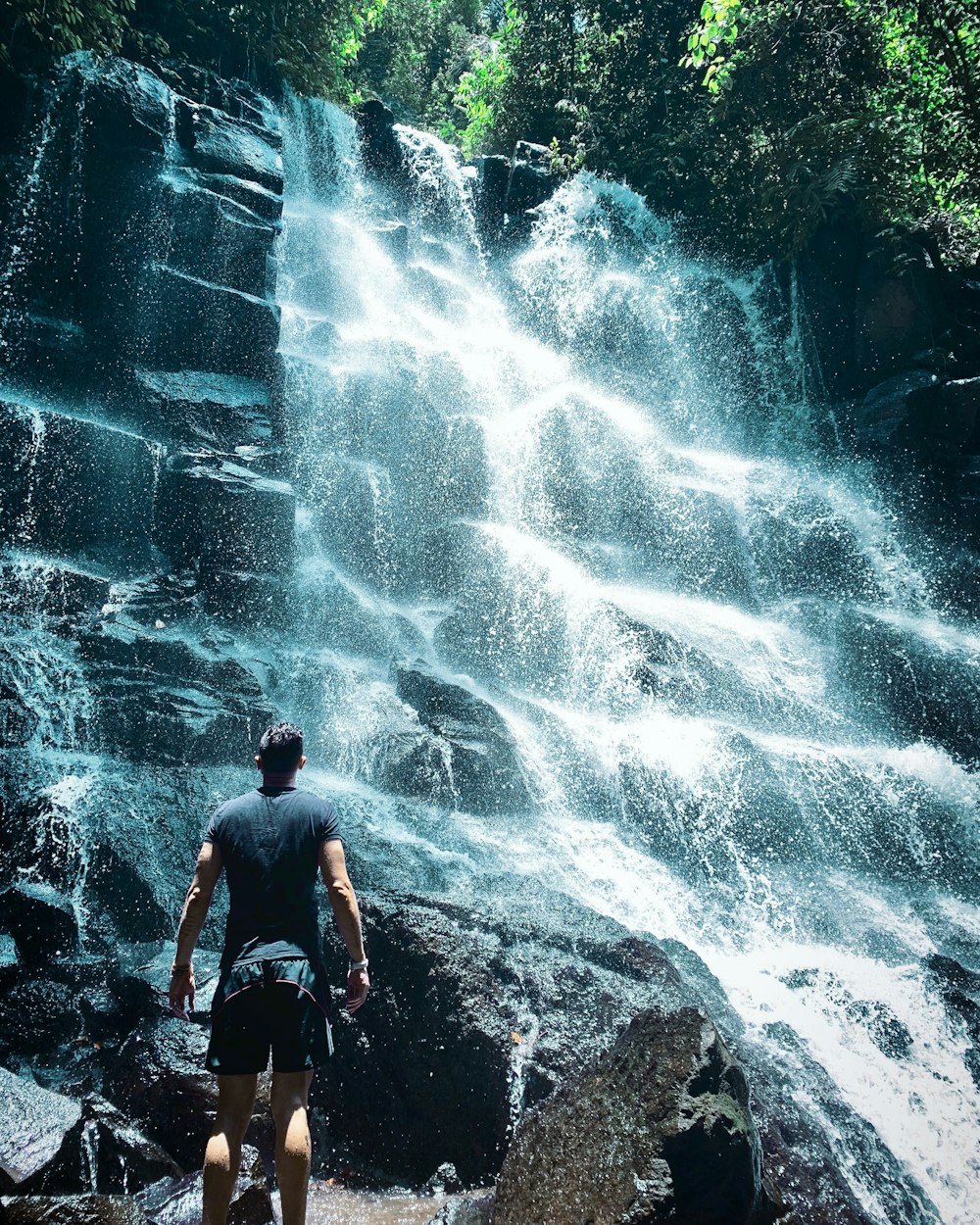 man standing beside falls