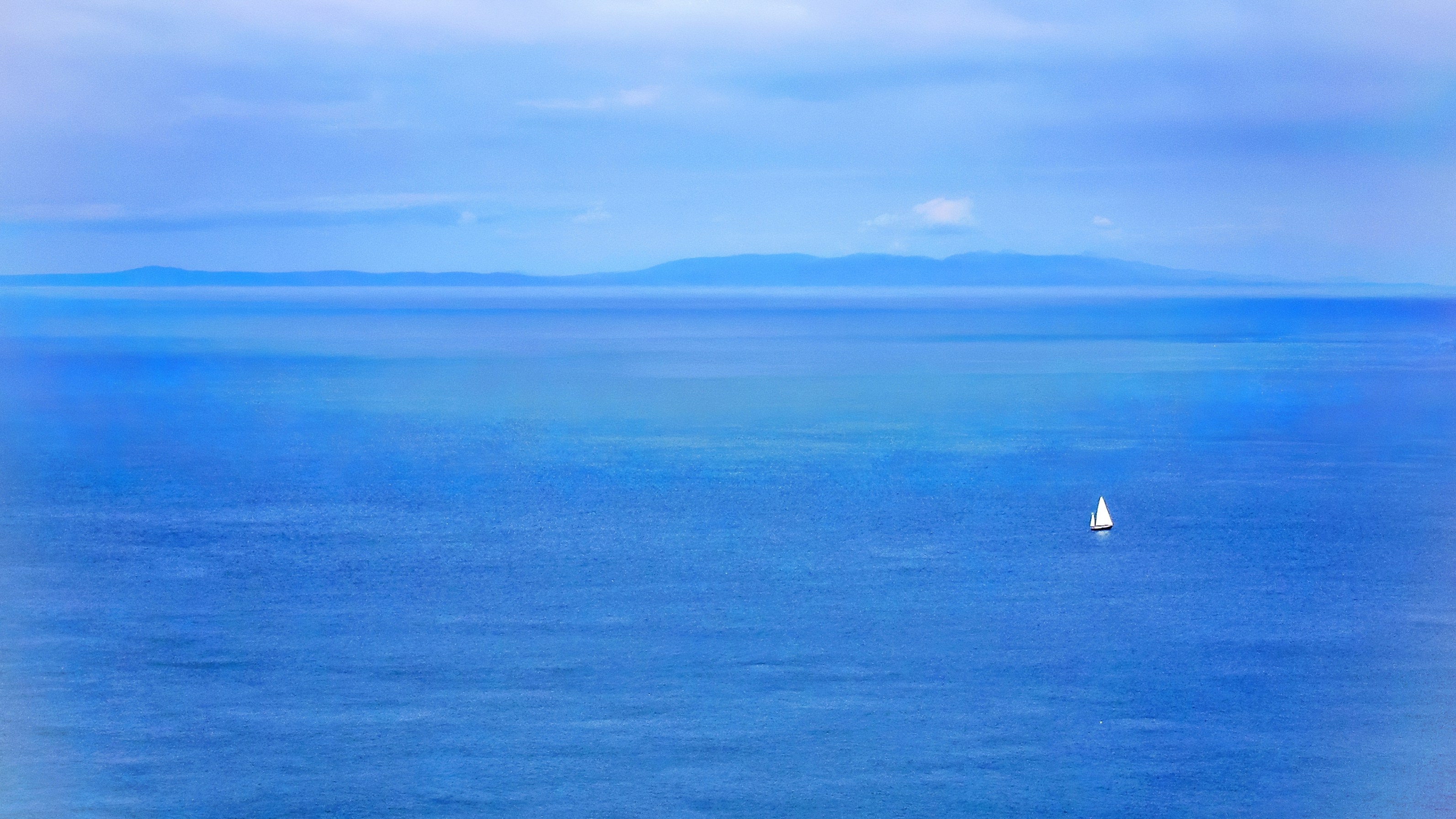 clear blue sea, The coast of Scotland is visible in the background.