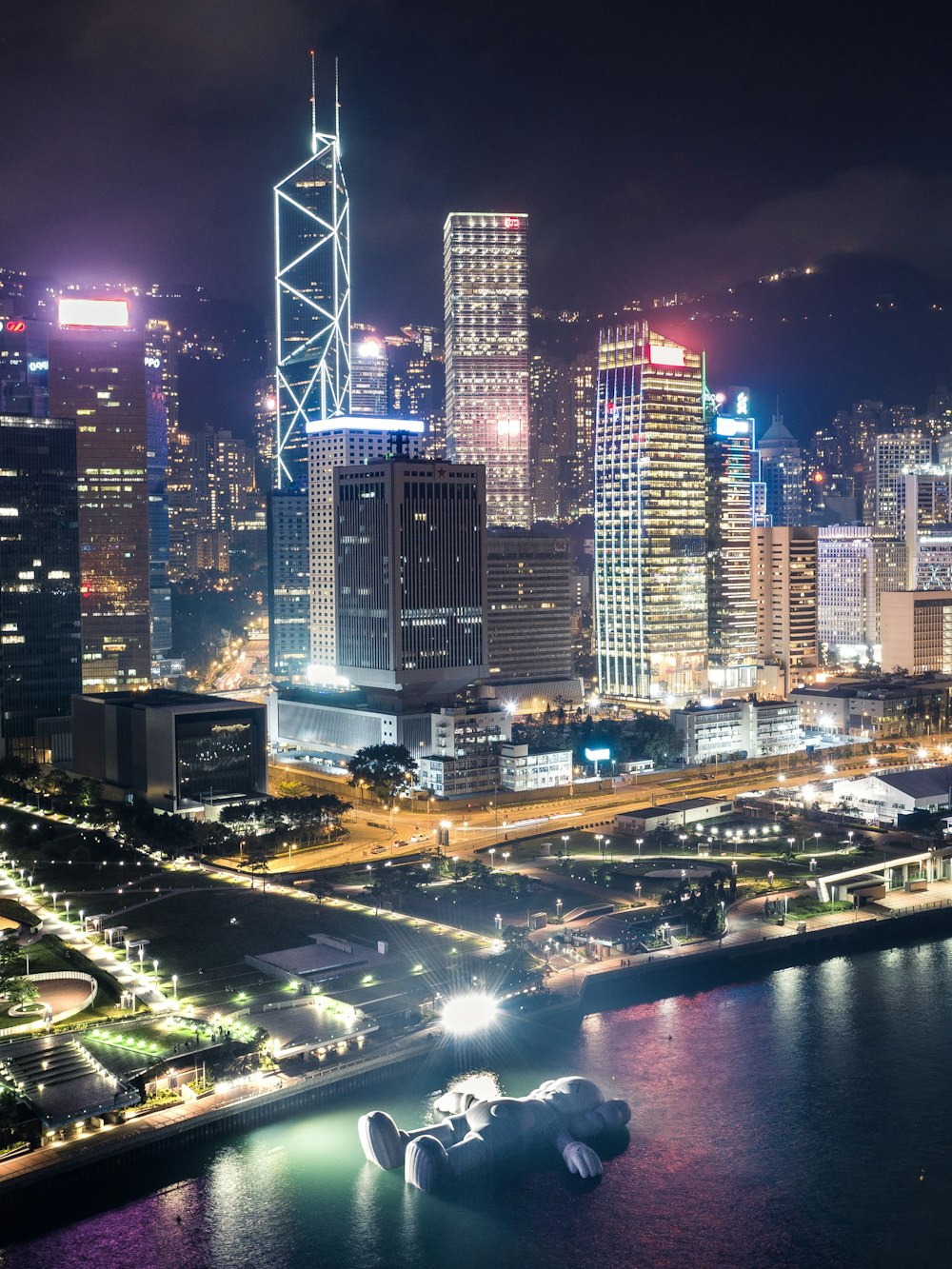 a city skyline at night with a river running through it