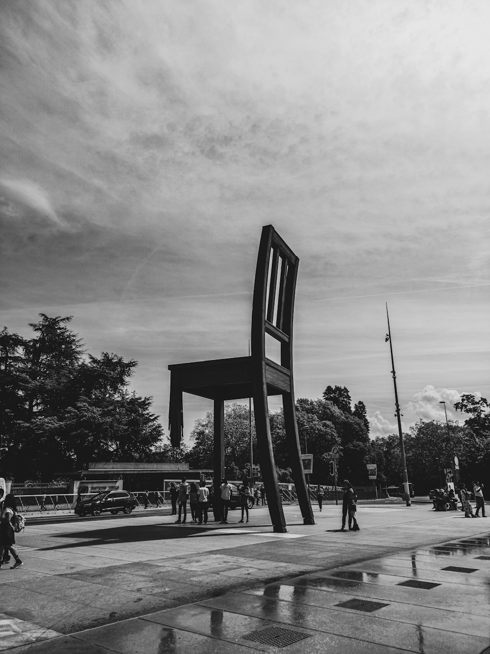 people gathering near armless chair sculpture during daytime