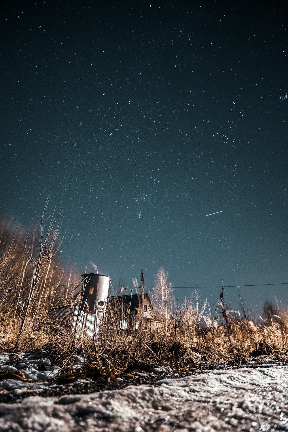 a chair sitting in the middle of a field under a night sky