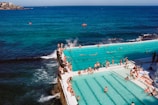 A panoramic view of the wave pool filled with smiling people enjoying the sunny day.