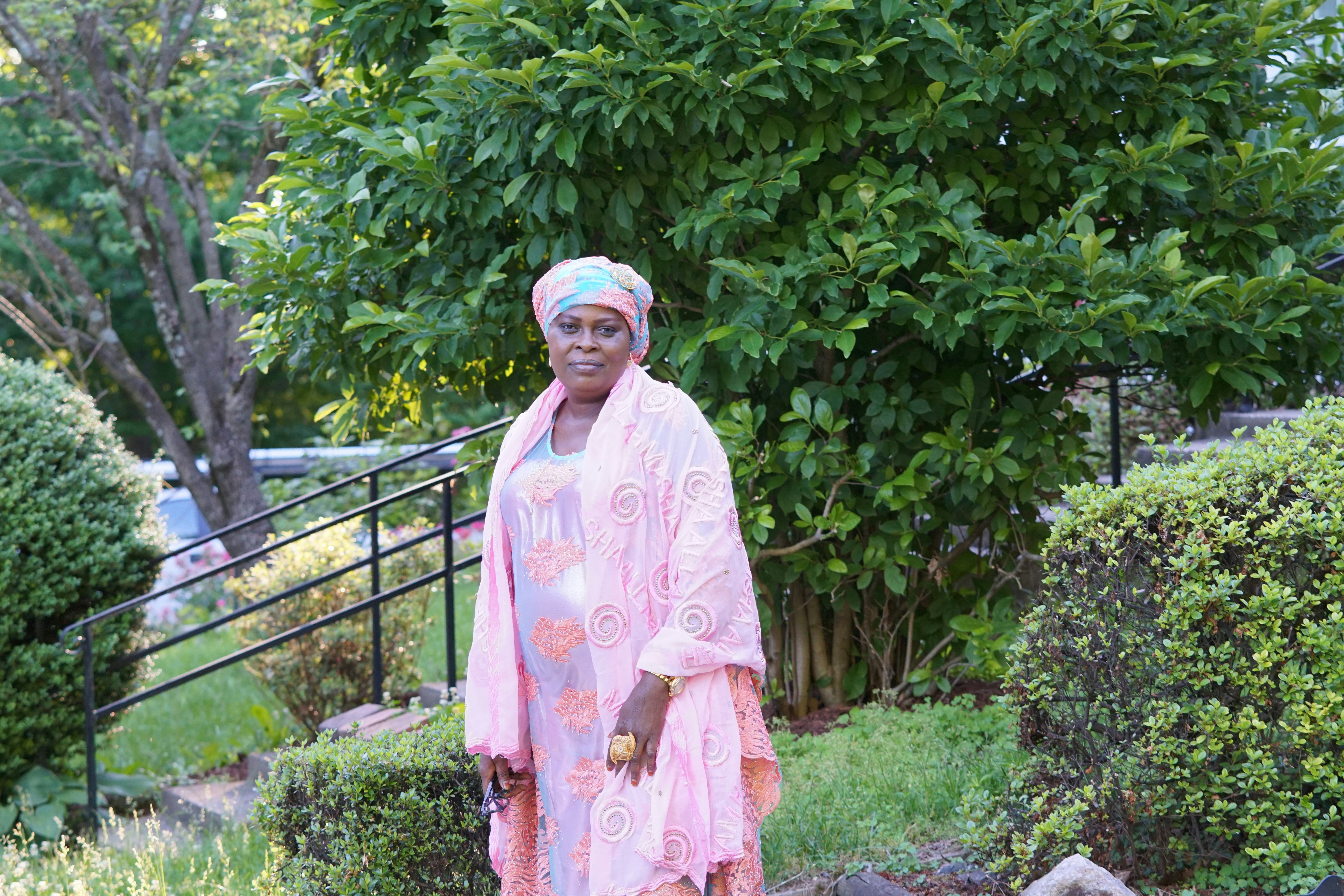 woman wearing pink dress standing near trees