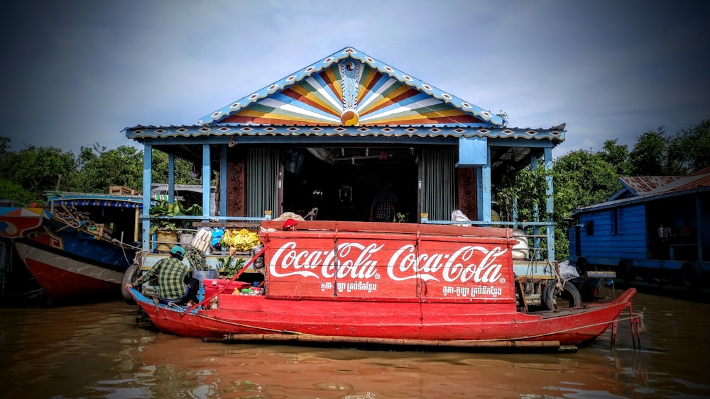 a red boat with a coca cola advertisement on it