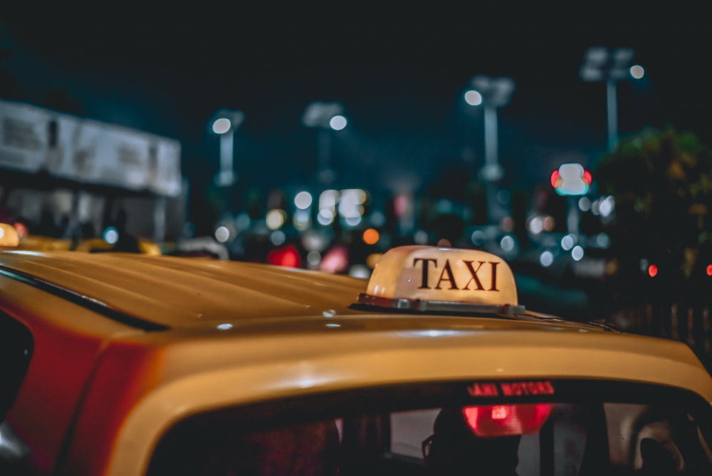 yellow taxi parked near road