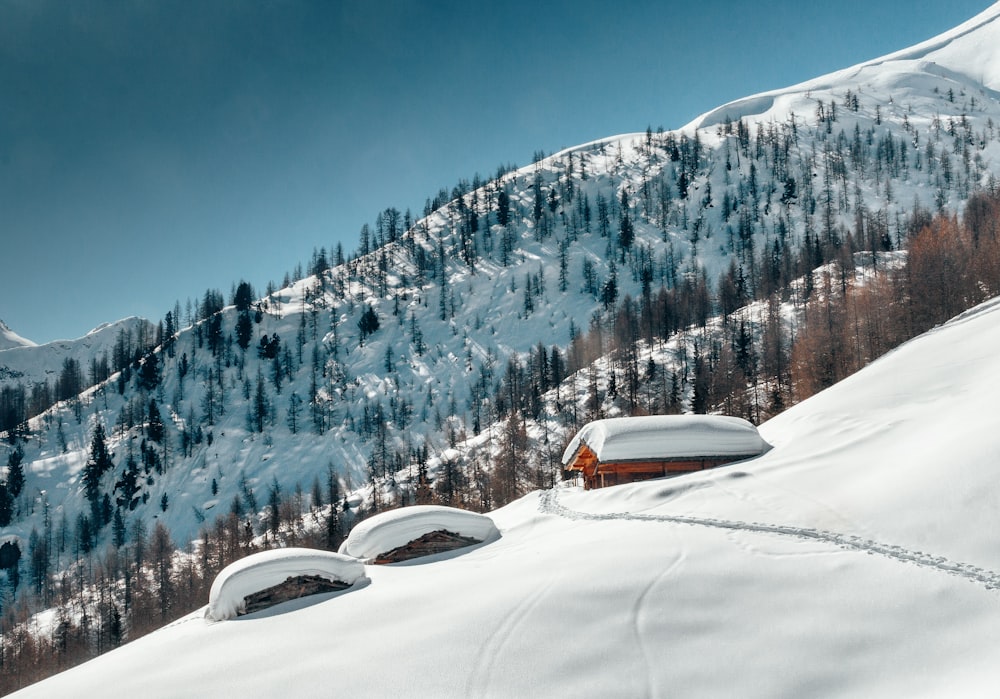 a snow covered mountain with a house on top of it