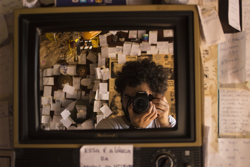 man taking photo in front of mirror