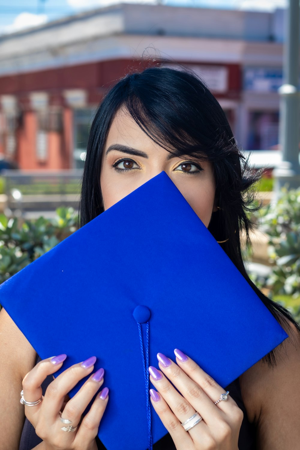 woman holding mortar hat in front of face