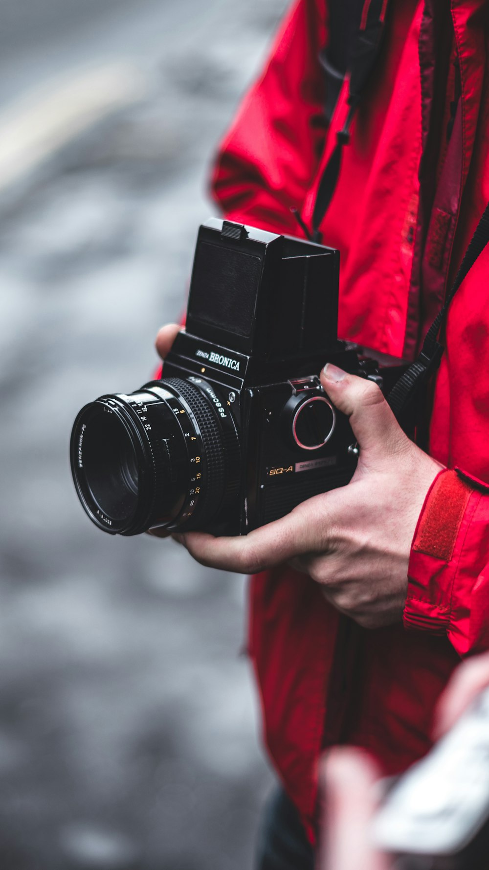 selective focus photography of person holding black DSLR camera