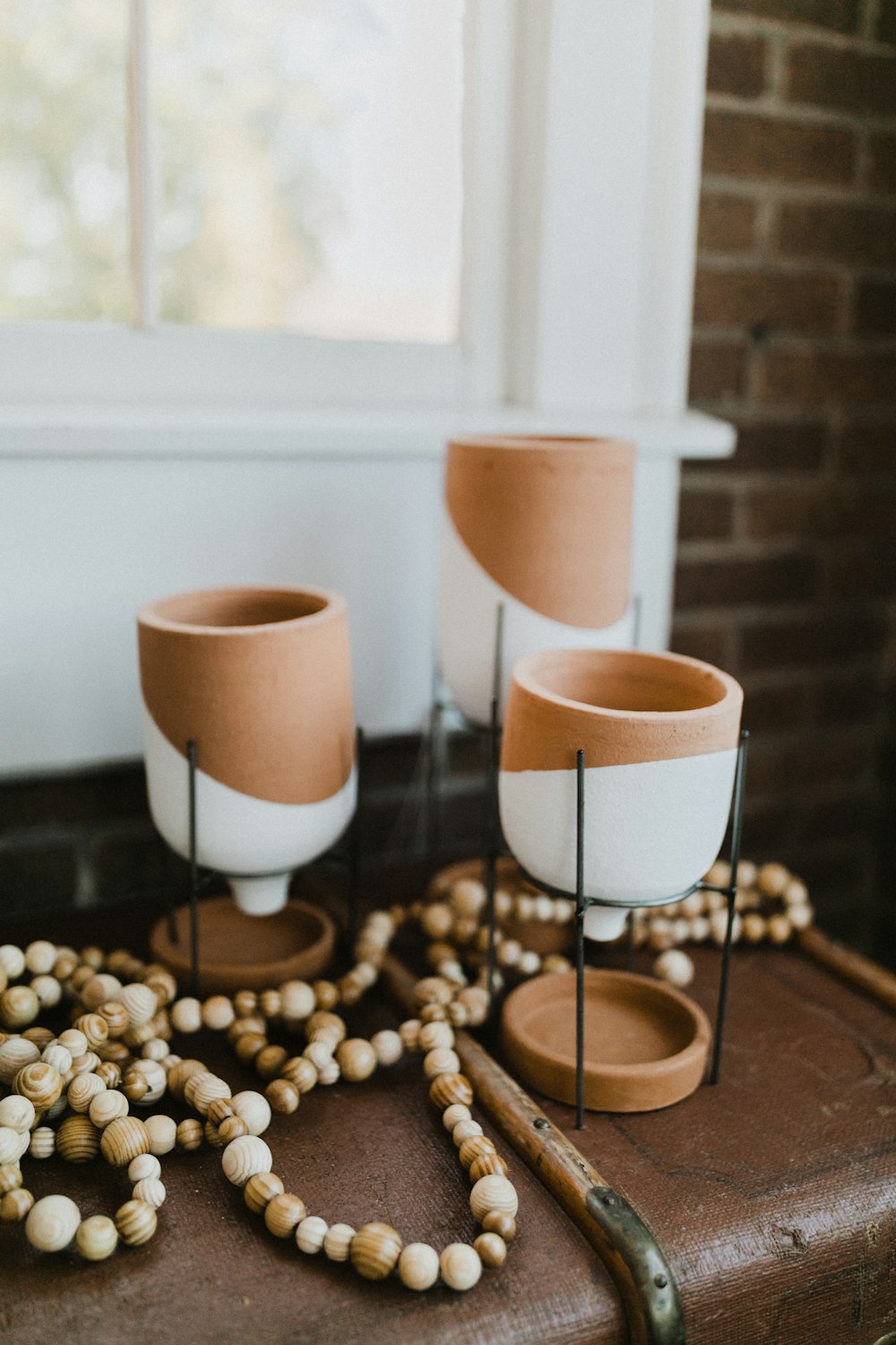 three white and brown ceramic candle holders on desk