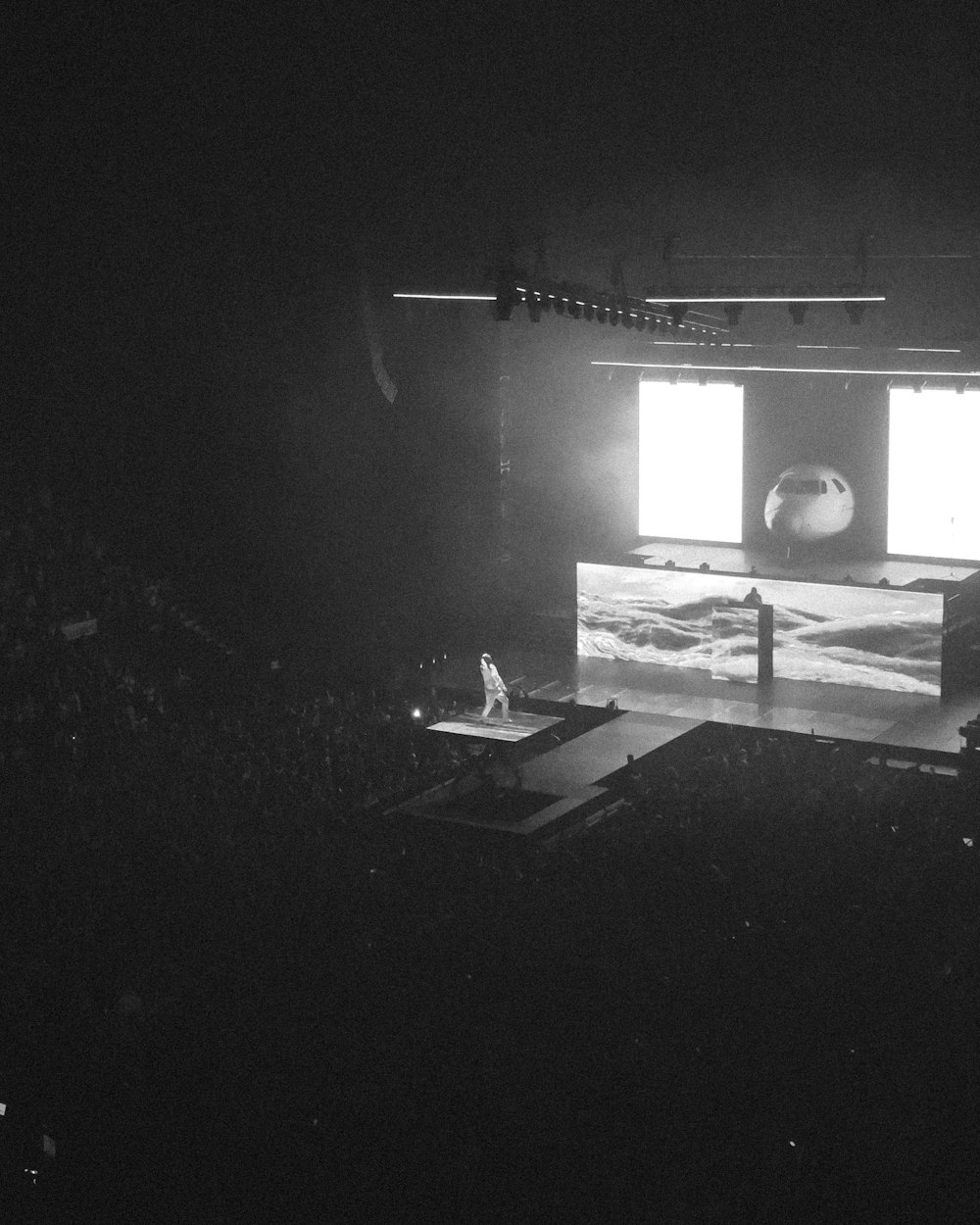 performer standing on platform lift at the stage during concert