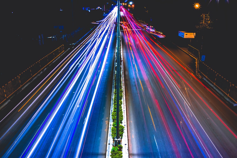 vehicles with lights passing bridge at night