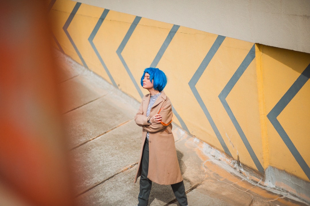 person standing beside building wearing brown coat