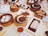 An assortment of dim sum dishes is arranged on a table. Wooden steamers hold items like buns and dumplings, while small plates display various dishes including chicken feet and rice noodles in sauce. A white teapot and cups filled with tea are also present, alongside dipping sauces.