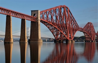 Film company: red metal bridge near a white metal bridge during the daytime