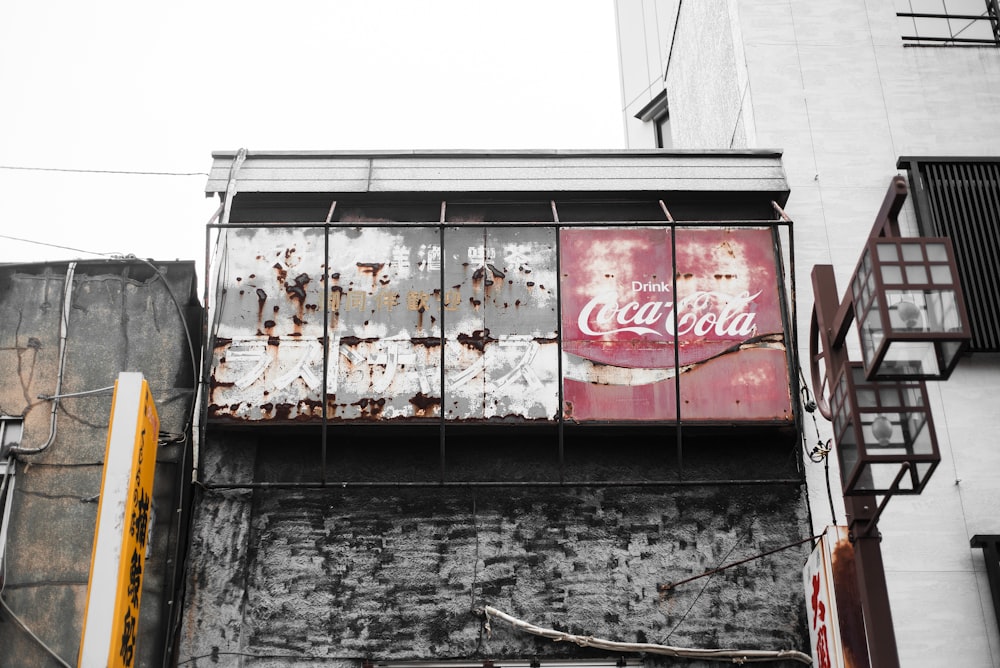 rusted Coca-Cola sign during daytime