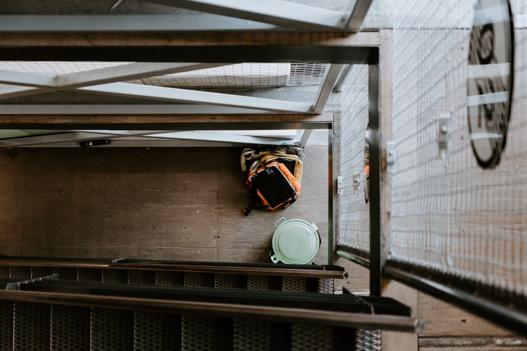 orange backpack beside trash bin