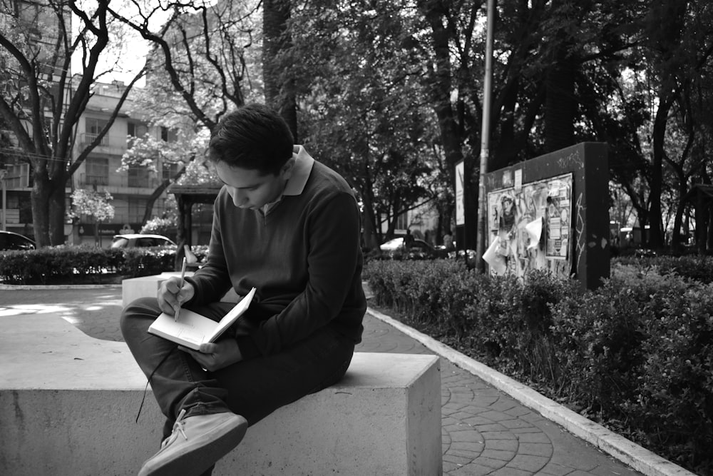 grayscale photo of man reading book