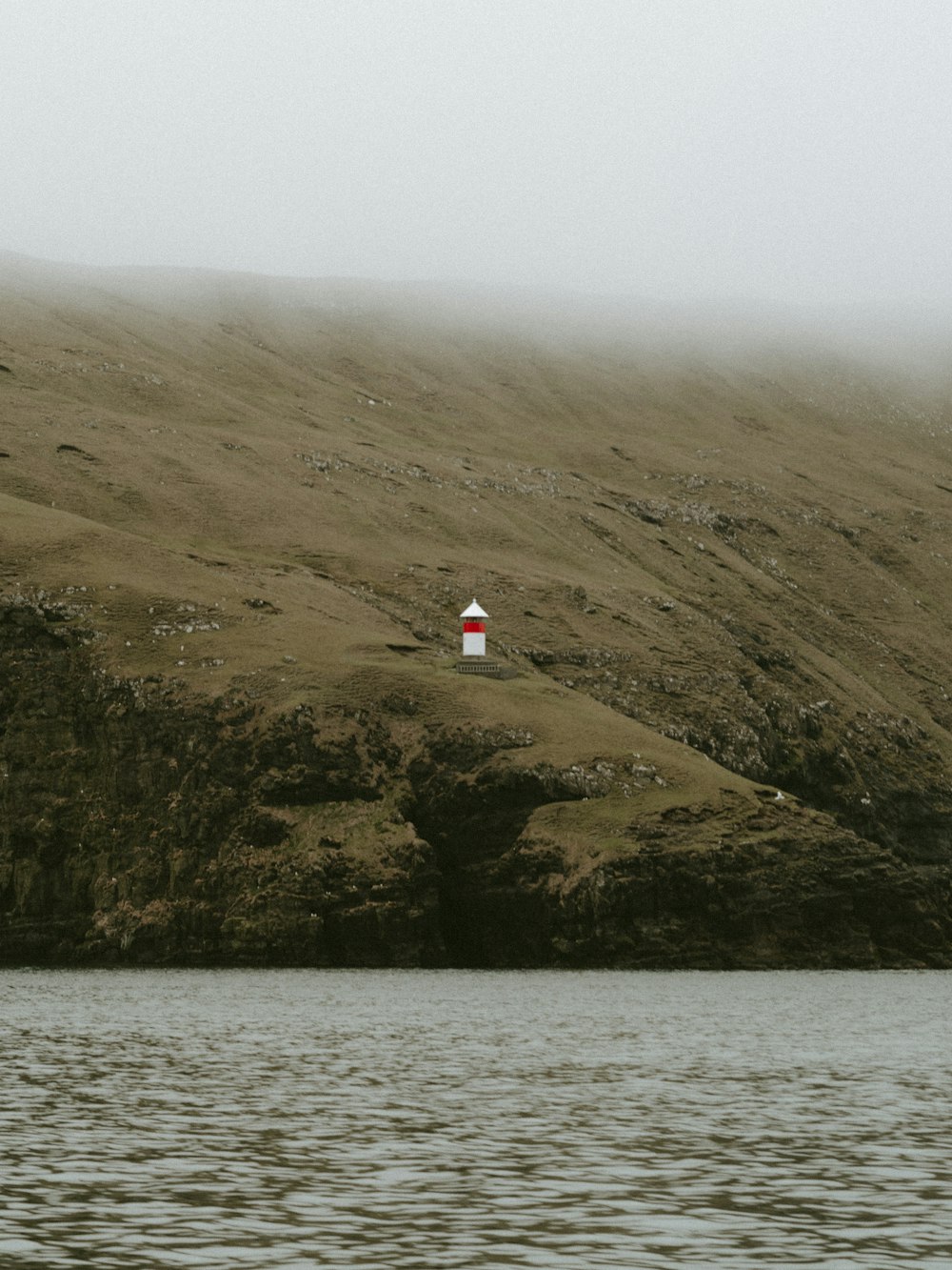 lighthouse on cliff during daytime